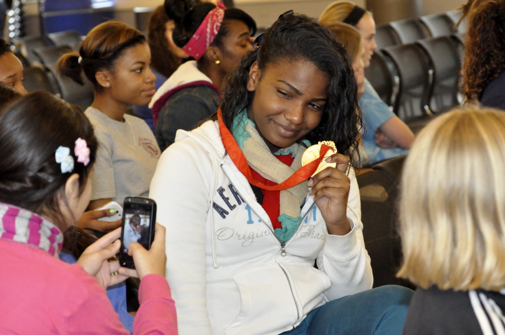 Attendees pose with Heather Mitts' Olympic gold medals during her keynote. (Photo: Cayla Teller)